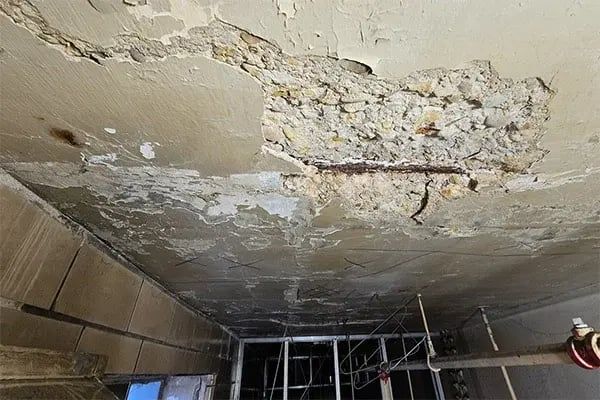 Concrete spalling and exposed corroded reinforcement, basement garage ceiling, Drummoyne