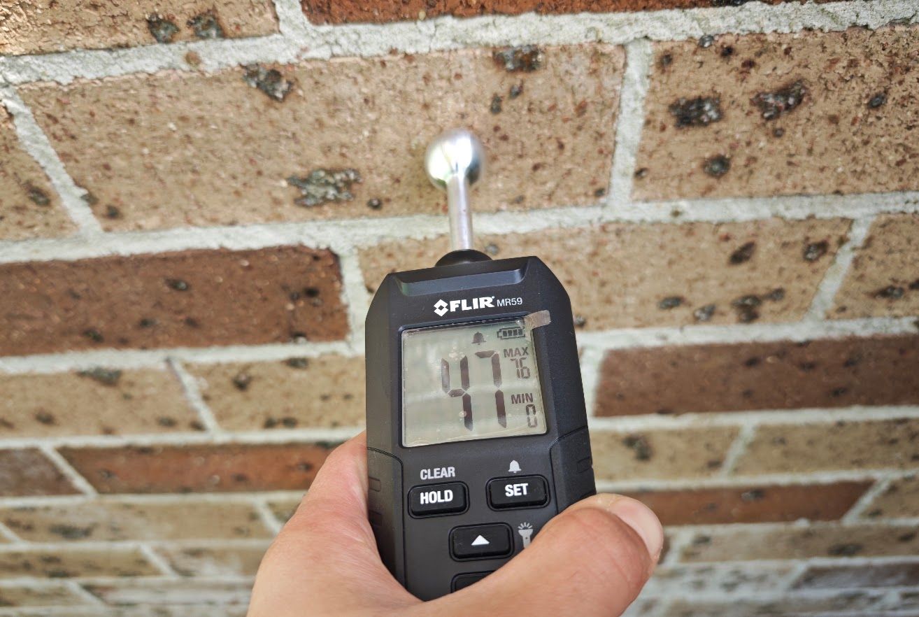 Moisture meter reading on brick wall, Eastwood